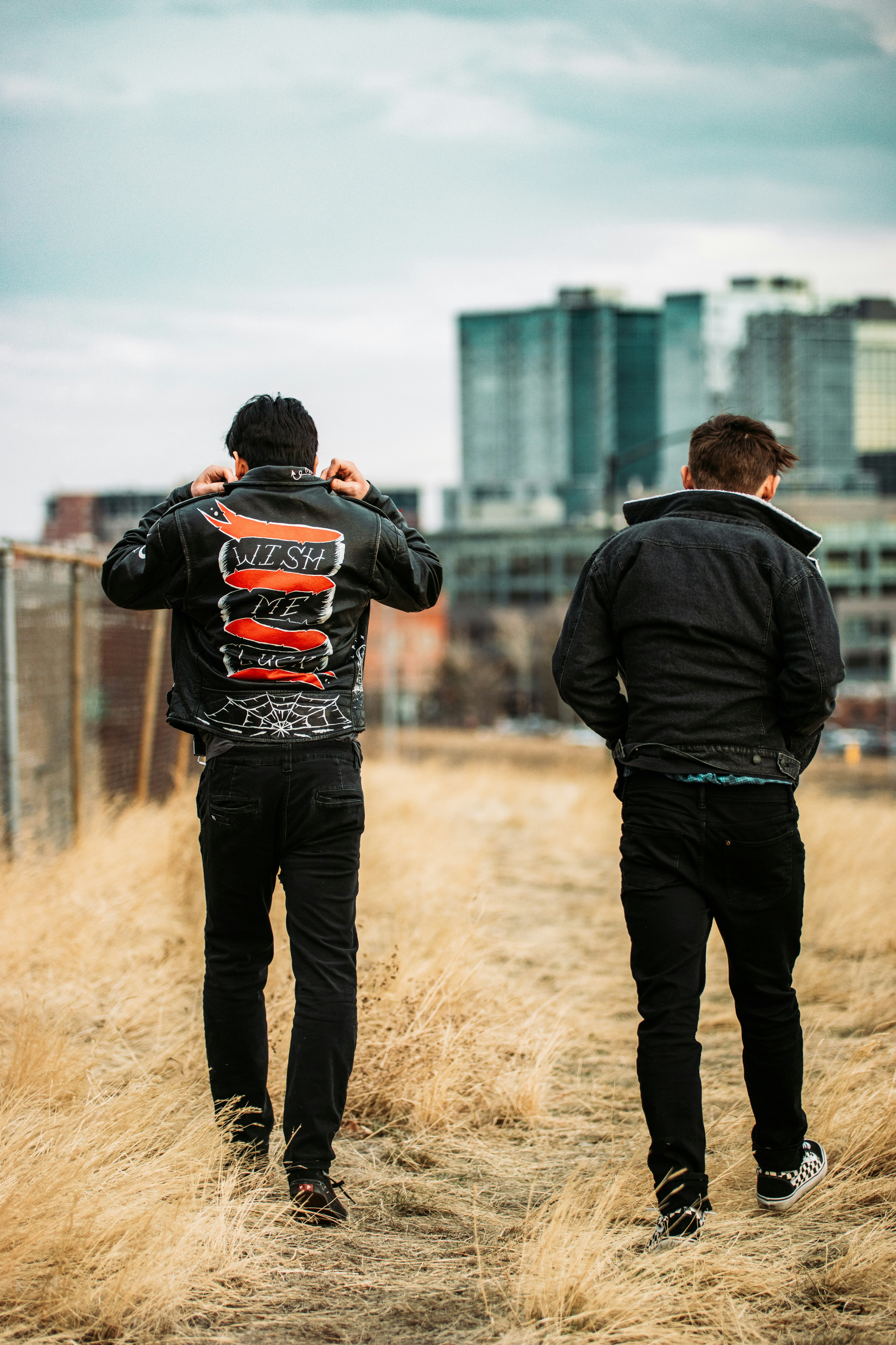 man in black jacket and black pants standing beside man in black jacket during daytime